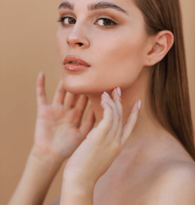 Beautiful young woman with clean perfect skin. Portrait of beauty model with natural nude make up and touching her face. Spa, skincare and wellness. Close up, copyspace. | CasaGlow MedSpa in New York, NY